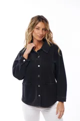 Sobrecamisa de jean color negro con cuello clásico, cierre frontal con botones metálicos, mangas largas con puños abotonados y bolsillos de parche en el pecho.