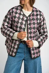 Campera acolchada color verde militar, con cuello redondo y cierre frontal de broches a presión. Presenta un patrón de costuras onduladas.