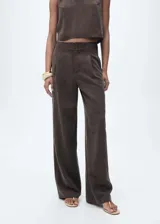Pantalón marrón de lyocell de tiro medio, corte recto y diseño largo. Cuenta con cierre de cremallera y doble botón, trabillas, detalle de pinzas y dos bolsillos laterales.