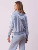 Campera de algodón celeste con capucha, cierre frontal y bolsillos aplicados. Terminación de puños y ruedo acanalado.