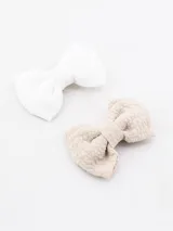 Pack de dos broches para el pelo con forma de moña, uno color crudo y otro color blanco.