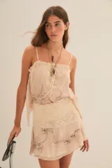 Minifalda color crema con estampado floral, cintura con encaje y volados.