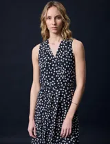Vestido largo Donna Ricco de gasa color negro con estampado de lunares blancos, escote en V cruzado, sin mangas, cintura con lazo de ajuste y forro interno.