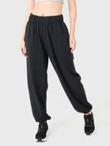 Pantalón de buzo negro de tela suave, con cintura elástica, bolsillos laterales y traseros, y elástico en los tobillos.