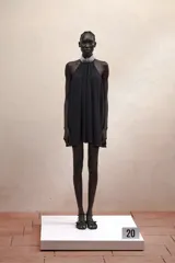Vestido corto negro con cuello halter con joyas, caída amplia y espalda descubierta.