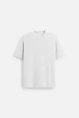 Camiseta gris claro de punto con cuello redondo, manga corta y corte regular.