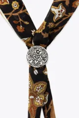 Pañuelo bandana de algodón y seda con estampado floral en tonos marrón, beige y negro. Incluye pieza metálica plateada en forma de corazón.
