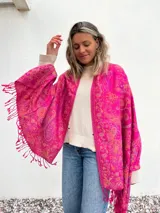 Pañuelo fucsia con estampado de arabescos en tonos naranja y violeta, con flecos en el borde.