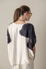 Blusa italiana color natural con estampado de hojas grandes en tonos marrones. Tiene cuello redondo y mangas cortas amplias.