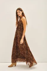 Vestido largo de gasa con estampado de piel de serpiente en tonos marrones y detalles de lurex. Presenta escote en V con tirantes finos y volados en el frente.