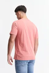 Remera color salmón de corte clásico, cuello redondo y logo bordado en el pecho.