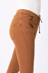 Pantalón marrón de corte skinny con cintura elástica y cordón ajustable.