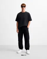 Pantalón cargo negro de tela liviana con bolsillos laterales, reguladores en puños y cintura.