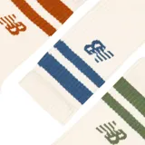 Pack de tres pares de medias New Balance unisex, color crudo con rayas horizontales en marrón, azul y verde.