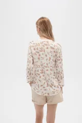 Camisa de viscosa con estampado floral en tonos azul, beige y blanco. Tiene cuello mao, mangas largas y bolsillos en el pecho.