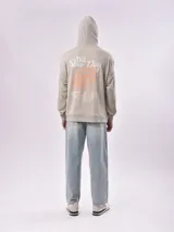 Canguro beige con capucha, bolsillo tipo canguro y puños y cintura acanalados. Estampado frontal con la frase "Lost Minds Waves California".