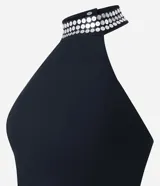 Blusa cropped negra de bengalina, con escote halter con lentejuelas y cierre en la espalda.