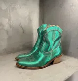Bota tejana de cuero verde metalizado con bordados en el empeine y taco de madera.