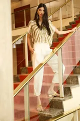 Pantalón sastrero color blanco, de tiro alto, con ajuste en el tobillo, bolsillos delanteros y traseros, y pinzas en el frente.