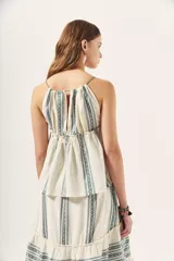 Top blanco con estampado de líneas verticales en verde y escote halter con tirantes finos.