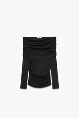 Camiseta negra de algodón con escote recto, hombros descubiertos y mangas largas. Presenta detalle de frunces en el frente.