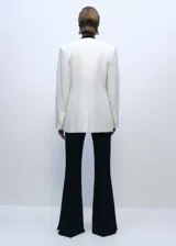 Pantalón negro de vestir, tiro medio, corte wide leg y aberturas laterales en el ruedo.