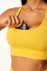 Top deportivo amarillo con diseño nadador, bolsillo trasero y bolsillo interno en el forro frontal.