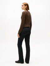 Pantalón de jean bootcut de tiro medio, color azul oscuro, confeccionado en denim de algodón elástico. Presenta pespuntes a contraste, cierre de cremallera con botón y estilo de cinco bolsillos.