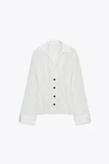 Camisa blanca con rayas verticales finas en color gris, de corte entallado, con cuello solapa y escote en pico. Cierre frontal con botones negros.