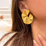 Par de aros dorados con diseño abstracto de pétalos.