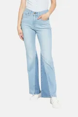 Pantalón de jean celeste con corte flare y diseño de parches en diferentes tonos de azul.