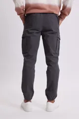 Pantalón cargo estilo jogger color gris oscuro, con bolsillos laterales y tobillos ajustados con elástico.
