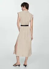 Vestido camisero midi color beige, sin mangas, con cuello camisero, cinturón ajustable y aberturas laterales.