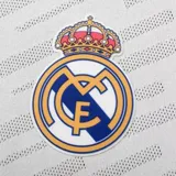 Camiseta de fútbol azul marino para niño, con cuello redondo y mangas cortas. Presenta el escudo del Real Madrid bordado en el pecho y detalles de líneas diagonales en el tejido.
