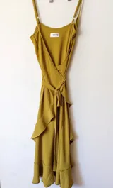 Vestido midi color mostaza, de corte cruzado con volados y breteles finos.