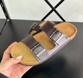 Sandalias marrones con plantilla color suela y doble tira con hebilla metálica.