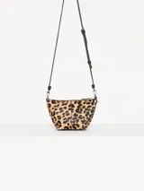 Bandolera confeccionada en cuero con estampado animal print, detalles en cuero vacuno y cadena metálica plateada en el frente. Tiene correa regulable de cuero y bolsillo interno con cierre.