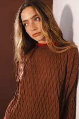 Sweater tejido rojo con cuello alto y puños con volados azules.