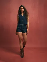 Chaleco azul oscuro de denim con botones y terminación desflecada.