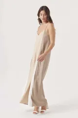 Mono largo de diseño holgado con breteles finos y escote en V. Presenta un diseño tricolor con bloques verticales en beige, negro y blanco.