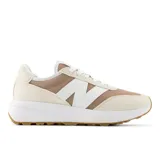 Championes New Balance modelo 370, color beige con detalles en blanco y suela marrón.