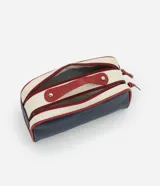 Neceser tipo baúl con dos compartimentos cerrados con cremallera, asa superior y tiradores. Diseño liso en azul marino y blanco con detalles en rojo.