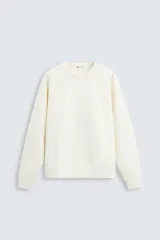 Sudadera color crema de algodón, corte relaxed fit, con cuello redondo, mangas largas y terminaciones en rib.