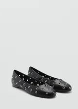 Zapato tipo ballerina color blanco con perforaciones circulares y punta redonda.