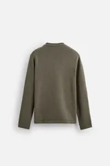 Jersey color beige de punto con cuello redondo y manga larga.