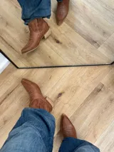Bota corta texana color marrón de cuero, con forro de cuero, taco bajo y punta cuadrada.