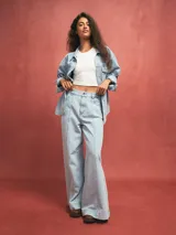 Pantalón de jean celeste de corte acampanado con costuras verticales en el frente.