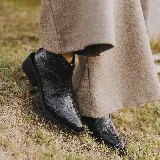 Botas cortas de cuero color marrón con cierre lateral, taco de madera de 5cm y suela de caucho.