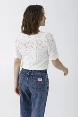 Pantalón de jean azul de tiro alto, corte recto y lavado claro con efecto nevado. Presenta pinzas en la cintura y bolsillos delanteros y traseros.