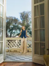 Pantalón oversize de pierna ancha color beige, con pliegues y bolsillos laterales.